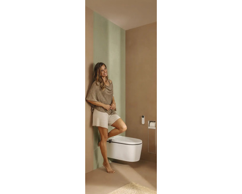 Modernes Badezimmer mit wandhängendem Dusch-WC, Fernbedienung, integriertem Toilettenpapierhalter und einer Frau.