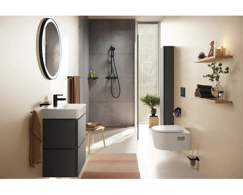 Modernes Badezimmer mit anthrazitfarbenem Waschtisch, rundem LED-Spiegel, ebenerdiger Dusche und weißem Wand-WC.