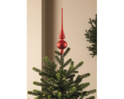 Rote Christbaumspitze in matter Optik auf einem grünen Weihnachtsbaum mit kleiner Beleuchtung.