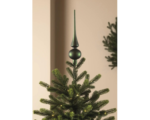 Mattgrüne Christbaumspitze auf einem künstlichen Weihnachtsbaum mit Beleuchtung.