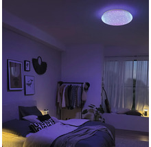 Modernes Schlafzimmer mit runder LED-Deckenleuchte mit Sternenhimmel-Effekt und lila stimmungsvoller Beleuchtung.