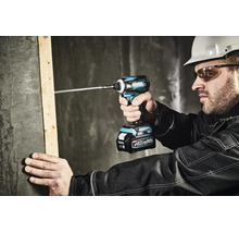Bauarbeiter schraubt mit einem Makita 40 Volt Akku-Schlagschrauber eine lange Schraube in einen Holzbalken an einer Betonwand.