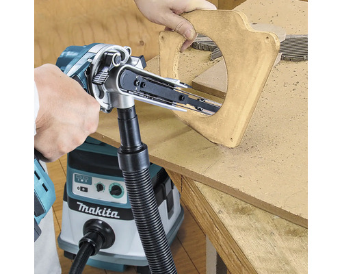 Makita Akku-Bandfeile beim Schleifen einer runden Aussparung in Holz, angeschlossen an ein Makita Absauggerät zur Staubminimierung.