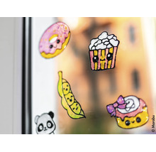 Selbstgemachte Fensterbilder aus Window Color mit niedlichen Motiven wie Donut, Popcorn und Erbsenschote auf einer Glasscheibe.