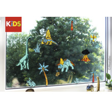 Marabu Kids Logo, Fensterbilder mit verschiedenen Dinosaurier-Motiven, Palmen und einem Vulkan auf einer Fensterscheibe.