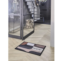 Moderne Diele mit einer Fußmatte mit geometrischem Muster und dem Schriftzug home auf Fischgrätboden neben einer Glastür.