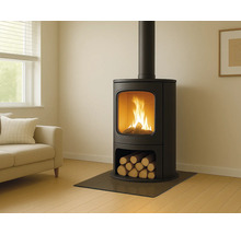 Moderner Kaminofen aus schwarzem Metall mit brennendem Feuer im Wohnzimmer, integriertem Holzfach und Glasbodenschutzplatte.