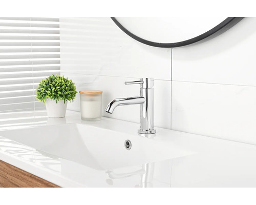 Einhebel-Waschtischarmatur aus Chrom auf einem Waschbecken in einem hellen, modern eingerichteten Badezimmer mit Spiegel und Pflanze.