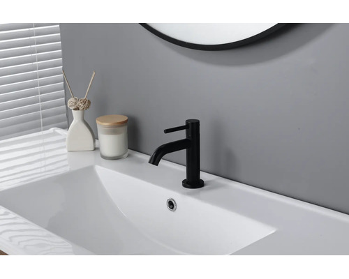 Schwarze Waschtischarmatur auf weißem Waschbecken in einem modernen, hellen Badezimmer.