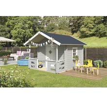 Ein graues Kinderspielhaus aus Holz mit Satteldach, kleiner Veranda und weißen Akzenten in einem hellen Garten mit Spielzeug und Loungemöbeln.