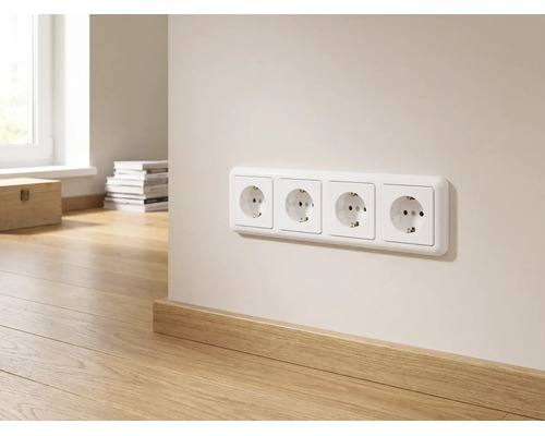 Vierfache Steckdose an einer hellen Wand über einer Holzsockelleiste in einem hellen, modern eingerichteten Raum.