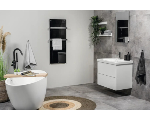 Modernes Badezimmer mit freistehender Badewanne, weißem Waschtisch, schwarzem Heizkörper und grauen Fliesen.