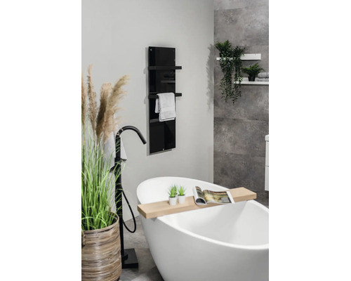 Modernes Badezimmer mit freistehender Badewanne, schwarzer Standarmatur und einem vertikalen Badheizkörper aus schwarzem Glas mit Handtuchhalter.