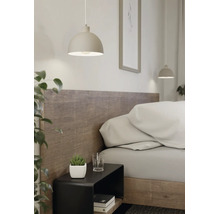 Moderne Pendelleuchte in Halbkugelform über einem schwarzen Nachttisch in einem hellen Schlafzimmer mit Holzkopfteil.