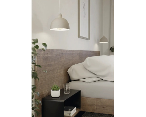 Moderne Pendelleuchte in Halbkugelform über einem schwarzen Nachttisch in einem hellen Schlafzimmer mit Holzkopfteil.