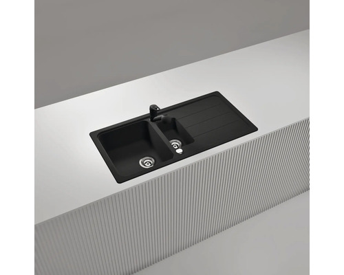 Einbau-Küchenspüle aus Granit-Verbundwerkstoff in Schwarz mit anderthalb Becken, Abtropffläche und passender schwarzer Armatur.
