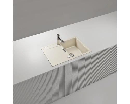Beige Einbauspüle mit Abtropffläche und verchromter Armatur, eingelassen in eine weiße Arbeitsplatte mit Lamellenfront.