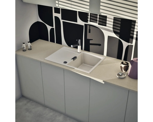 Moderne Einbauspüle mit Abtropffläche und Einhebelmischer in einer hellen Küche mit gemusterter Rückwand und schlichten Unterschränken.