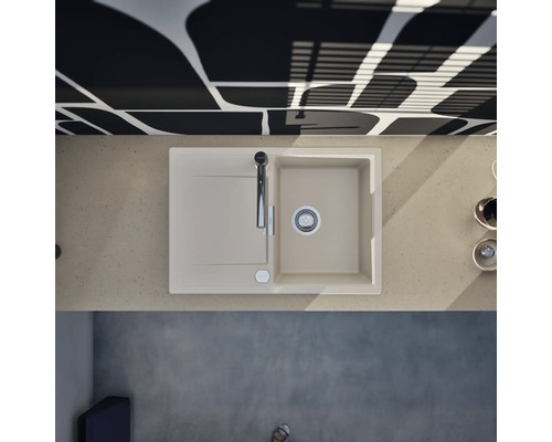 Moderne Küchenspüle mit Abtropffläche und Armatur in einer hellen Arbeitsplatte, kombiniert mit einer gemusterten Wand in einer hellen Küche.