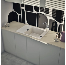 Moderne Küche mit Einzelspüle, Abtropffläche, verchromter Armatur und geometrischer Rückwand auf einer hellen Arbeitsplatte.