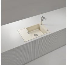Beige Einbauspüle aus Verbundwerkstoff mit einem Becken, Abtropffläche und Küchenarmatur, eingebaut in eine moderne helle Arbeitsplatte.