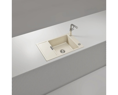 Beige Einbauspüle aus Verbundwerkstoff mit einem Becken, Abtropffläche und Küchenarmatur, eingebaut in eine moderne helle Arbeitsplatte.