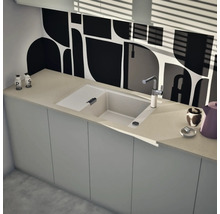 Moderne Einbauspüle mit Abtropffläche und Armatur in einer hellen Küche mit grafischem Fliesenspiegel.