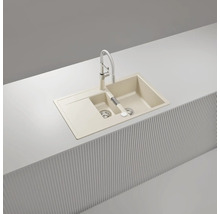 Einbauspüle mit zwei Becken, Abtropffläche und Küchenarmatur in Beige, hergestellt aus robustem Verbundmaterial.