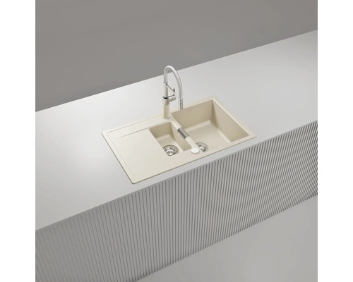 Einbauspüle mit zwei Becken, Abtropffläche und Küchenarmatur in Beige, hergestellt aus robustem Verbundmaterial.