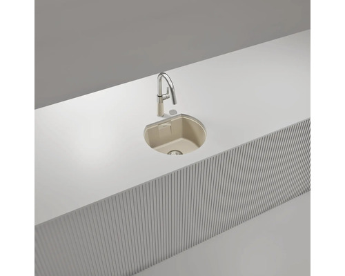 Beige Einbauspüle mit Einzelbecken in weißer Arbeitsplatte und moderner Hochdruckarmatur.