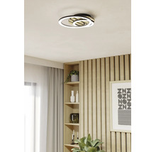 Moderne LED-Deckenleuchte mit zwei Ringen und Holzelementen in einem hellen Wohnraum mit Holzpaneelen.