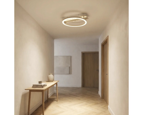Moderne LED-Deckenleuchte in Ringform im Flur mit hellem Parkettboden in Fischgrätoptik und schmalem Konsolentisch aus Holz.
