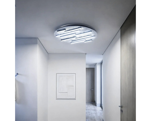 Moderne runde LED-Deckenleuchte mit linearen Lichtelementen in einem hellen, minimalistischen Flur mit Holzboden und strukturierten Oberflächen.