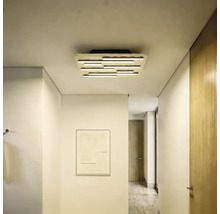 Moderne LED-Deckenleuchte mit horizontalen Lichtstäben in einem hellen, minimalistischen Flur mit weißen Wänden und Holztüren.