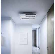 Moderne LED-Deckenleuchte mit mehreren parallelen Lichtstäben auf einer strukturierten Basis, montiert in einem hellen, minimalistischen Flur.