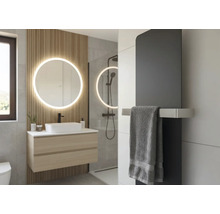 Modernes Badezimmer mit rundem beleuchtetem Spiegel, Wandpaneelen aus Holz, hängendem Waschtisch, Aufsatzbecken und dunklem Heizkörper.