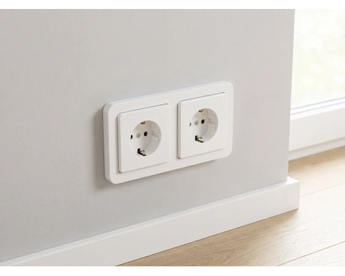 Doppelsteckdose Schuko montiert an einer Wand über einer weißen Fußleiste.