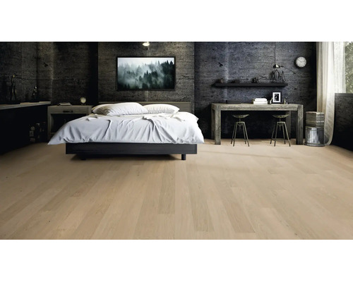 Heller Parkettboden in modernem Schlafzimmer mit dunklen Wänden in Betonoptik, weißem Bett und Holztisch.