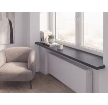 Moderne Raumszene mit dunkler Fensterbank über einem weißen Heizkörper, hellem Polstersessel und Holzfußboden.