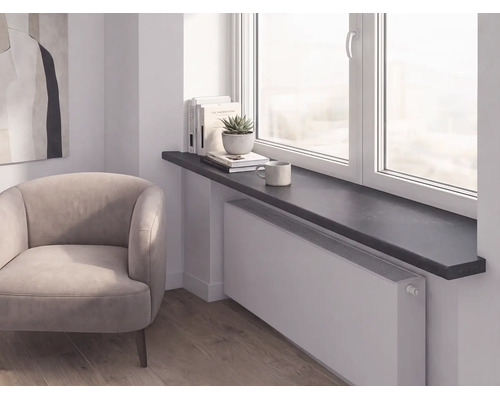 Moderne Raumszene mit dunkler Fensterbank über einem weißen Heizkörper, hellem Polstersessel und Holzfußboden.