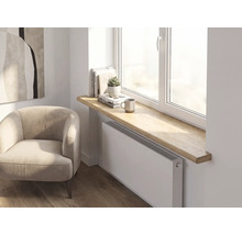Moderne Inneneinrichtung mit einer dicken Fensterbank aus Holz mit abgerundeten Kanten über einem Heizkörper in einem hellen, organisierten Raum.