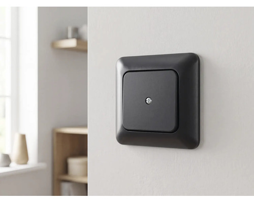 Mattschwarze quadratische Abdeckung mit Zentralschraube an einer Wand montiert in einem hellen, modern eingerichteten Raum.