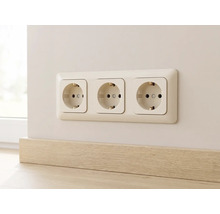 Dreifach-Schukosteckdose in einem Rahmen an der Wand montiert, direkt über einer Holzoptik-Fußleiste.