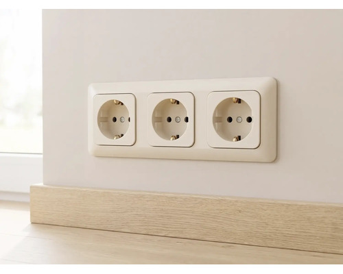 Dreifach-Schukosteckdose in einem Rahmen an der Wand montiert, direkt über einer Holzoptik-Fußleiste.