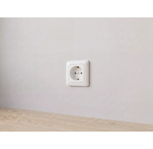 Weiße Schutzkontakt-Steckdose an einer Wand montiert.