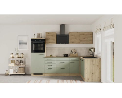 Moderne Einbauküche in L-Form mit salbeigrünen Fronten, Holzelementen, schwarzem Backofen und Dunstabzugshaube in einem hellen Raum.
