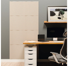 Moderner Arbeitsplatz mit Akustikpaneelen an der Wand. Die Paneele haben ein Wellenmuster. Schreibtisch mit Monitor und Laptop.