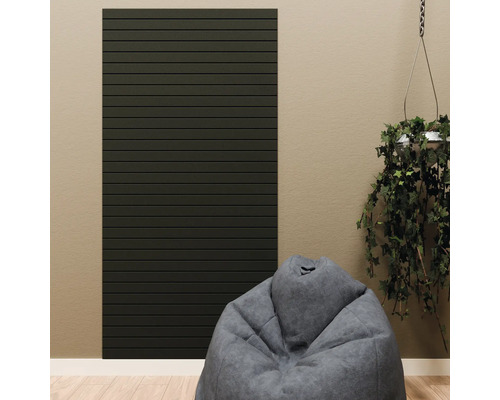 Dunkles Wandpaneel mit horizontalen Lamellen in einem modern eingerichteten Raum mit Sitzsack und Hängepflanze.