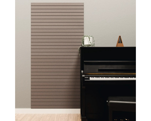 Akustikpaneel mit horizontalen Lamellen an einer Wand neben einem schwarzen Klavier in einem hellen Zimmer.
