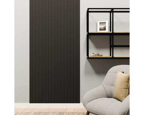 Dunkles Wandpaneel mit vertikalen Lamellen in einem modern eingerichteten Wohnzimmer neben einem schwarzen Wandregal und einem Sessel.